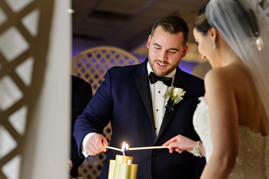 A wedding couple lighting thier unity candle.